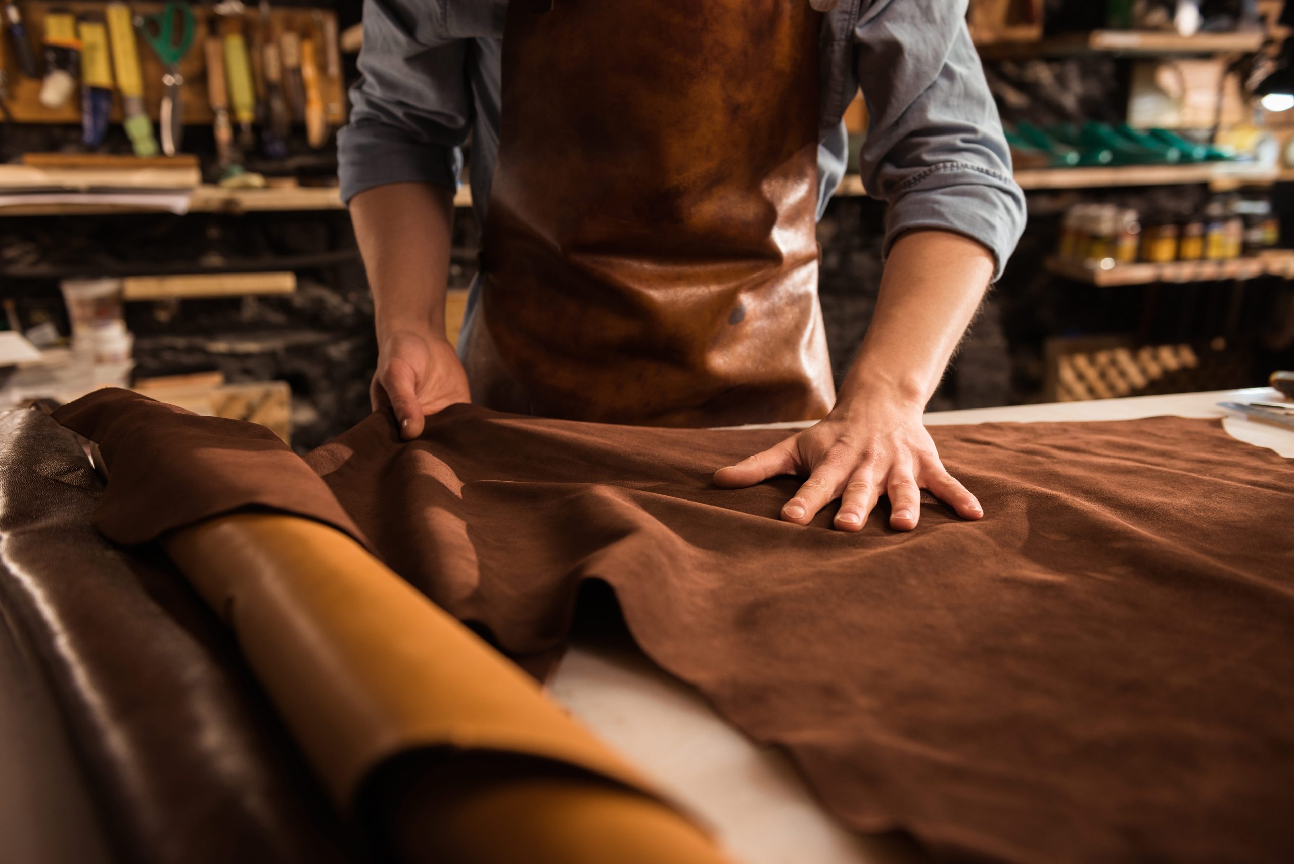 close up cobbler working with leather textile
